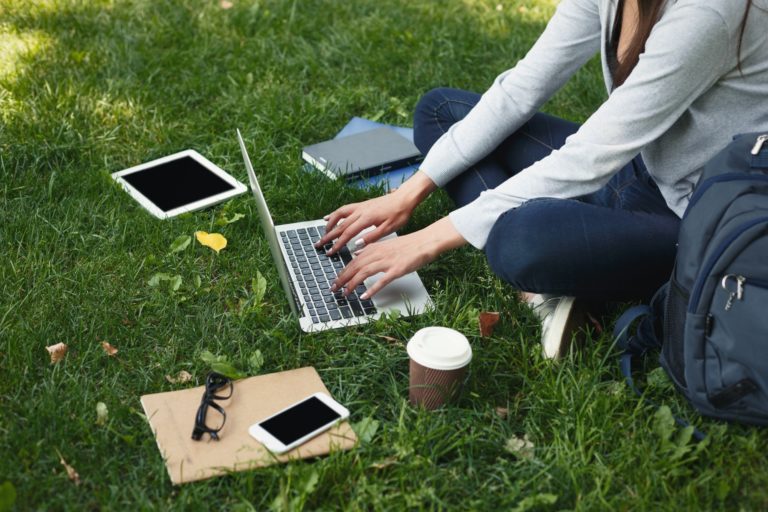 Young pensive woman using laptop in park